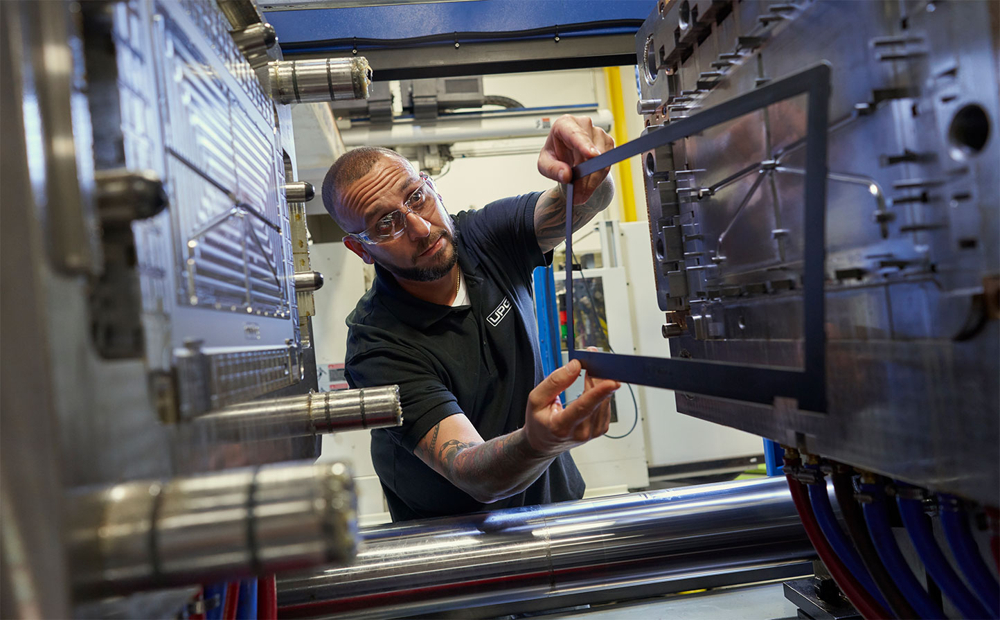 person working on large piece of manufacturing equipment